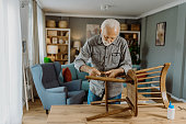 Senior man repairing his chair
