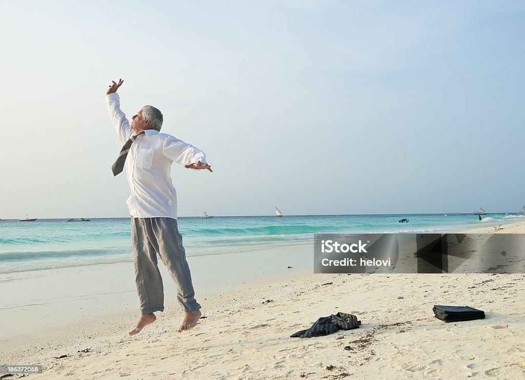 Hombre en ropa profesional salto en la playa. - Foto de stock de Hombres maduros libre de derechos