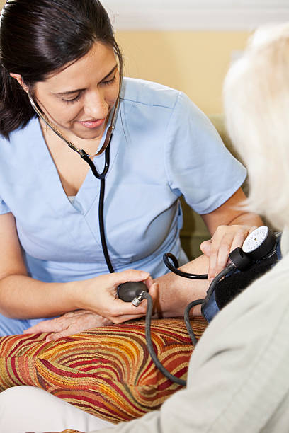 istock Nurse taking senior woman's blood pressure 185272281