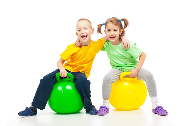 hermano y hermana heaving diversión con bola de rebote - bouncing ball family playing fotografías e imágenes de stock