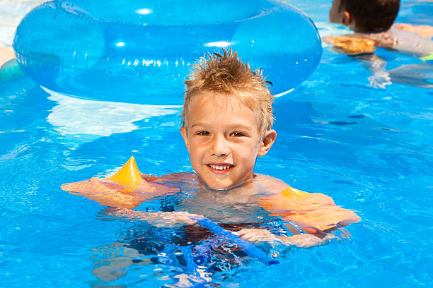 istock Child with water wings relaxing the swimming pool 185273230