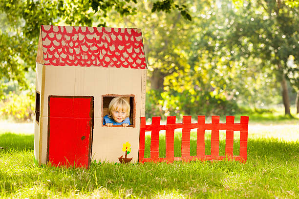 Boy Playing In a Playhouse Cute little boy playing in a playhouse. Horizontal Shot. Please checkout our lightboxes  playhouse stock pictures, royalty-free photos & images