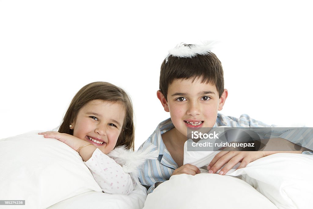 Pillow fight with white feathers Latin american siblings fighting with pillows 4-5 Years Stock Photo