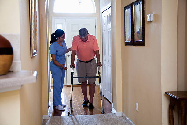 istock Home health aide with senior man using walker 185274314