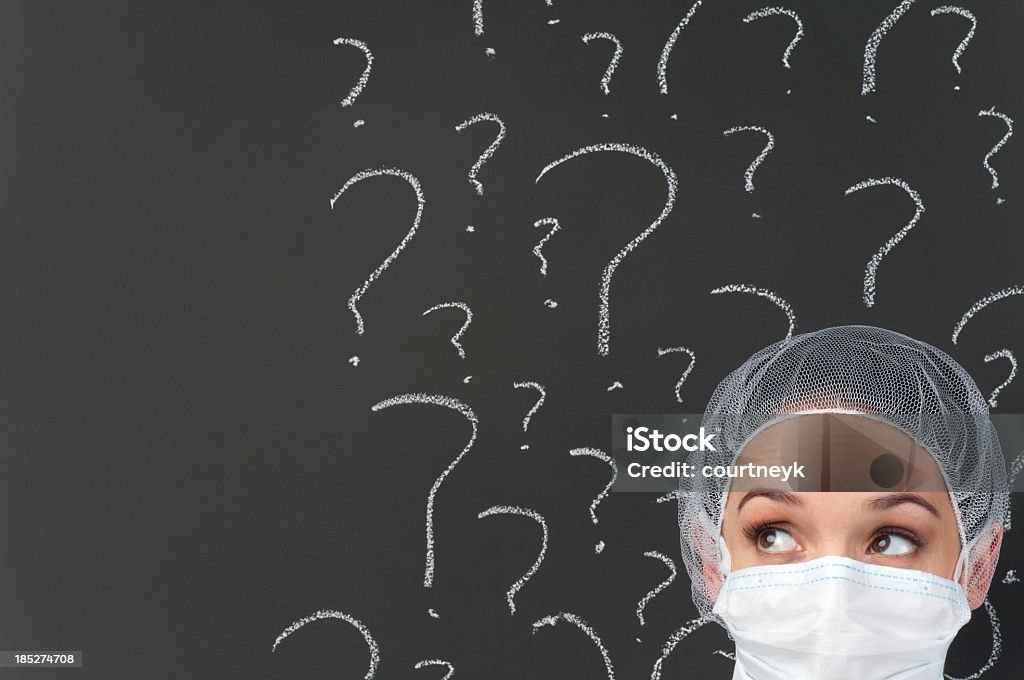 Feminino médico pensando na frente de Interrogação - Foto de stock de Confusão royalty-free