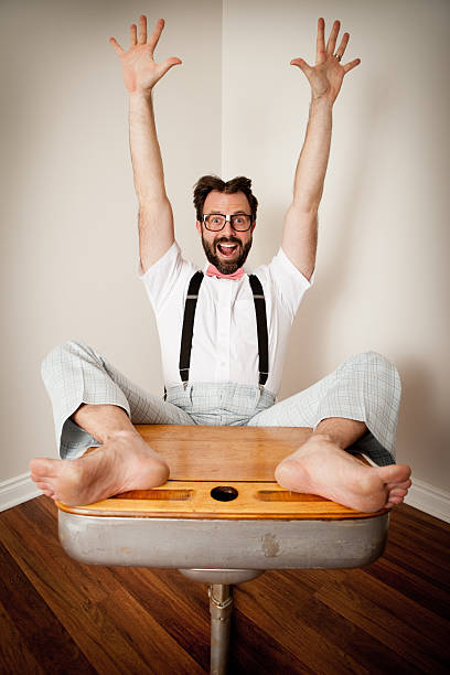 heureux pourtant homme assis avec les pieds sur l'école bureau - desk men bizarre classroom photos et images de collection