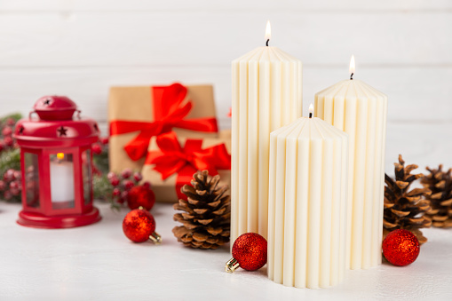 Christmas decoration with candle on texture background. New Year and Christmas candles. Cozy home decor. Burning candle and Christmas decoration. Christmas lights. Copy space.Holiday concept.