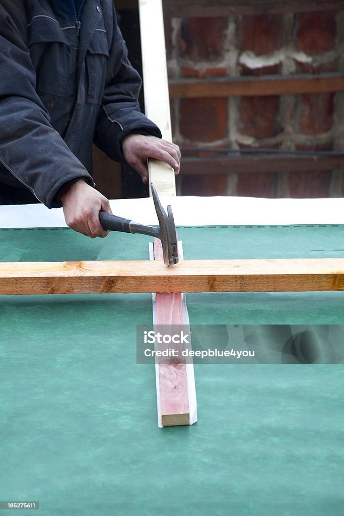 Trabajador de la construcción pulsando de uñas con martillo en madera - Foto de stock de Adulto libre de derechos