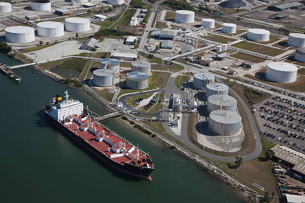 Aerial View of Crude Oil Tanker and Storage Tanks Crude oil tanker discharging crude oil to storage tanks jetty aerial stock pictures, royalty-free photos & images