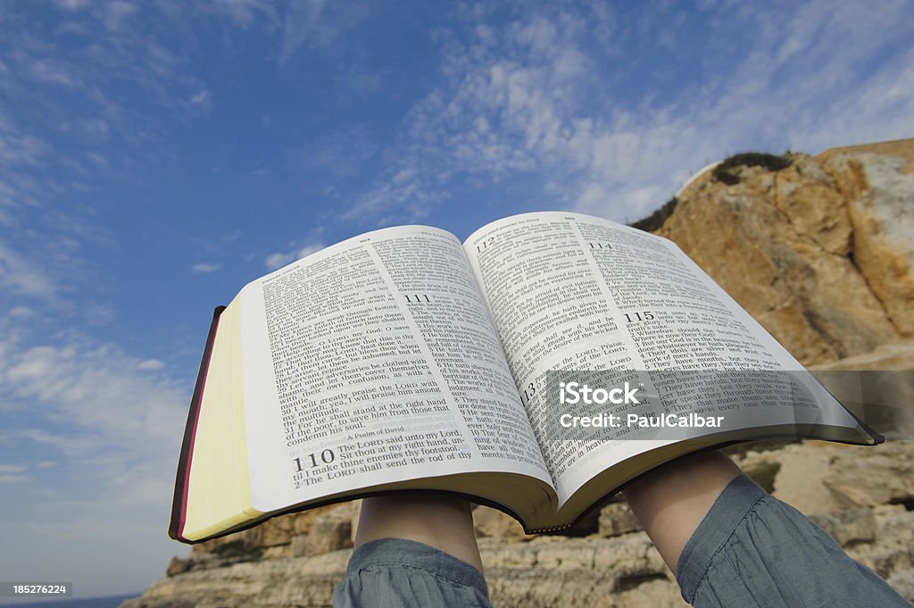 Bible raised to heaven Woman with open Bible in their hands raised to heaven. Bible Stock Photo