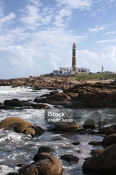 Lighthouse At The Ocean Coast With Waves Crashing On Rocks Stock Photo - Download Image Now