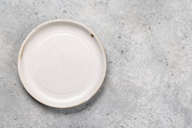 istock Mockup for a delicious meal. Empty plate on a table 1852776342