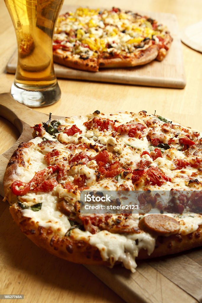 Pizza and Beer Supreme pizzas next to a cold glass of beer Alcohol - Drink Stock Photo