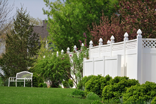 Beautiful new vinyl fence with nice landscaping in a backyard setting