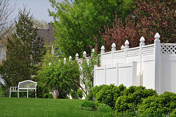 Vinyl Fence Beautiful new vinyl fence with nice landscaping in a backyard setting fence stock pictures, royalty-free photos & images