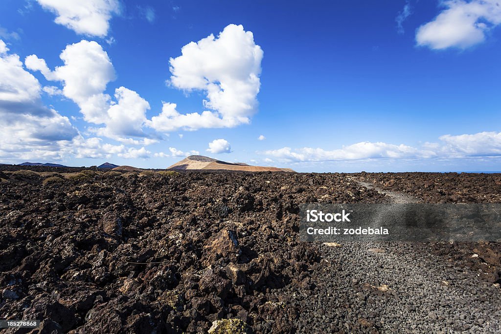 Trilha na paisagem vulcânica, Lanzarote, Ilhas Canárias - Foto de stock de Azul royalty-free
