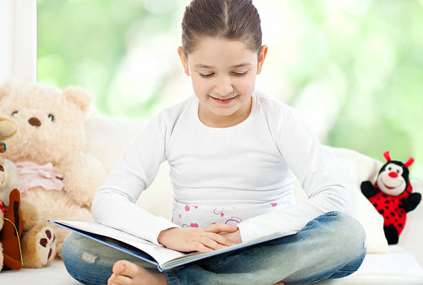 istock Beautiful little girl reading 185279041