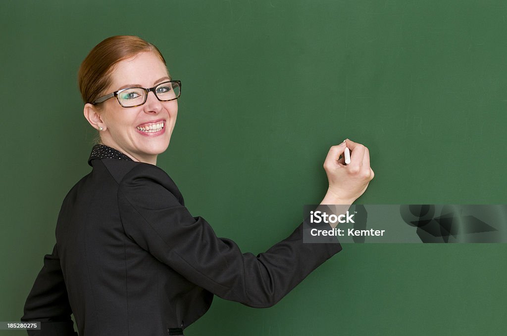 Profesor sonriente escribiendo en la pizarra - Foto de stock de 30-39 años libre de derechos