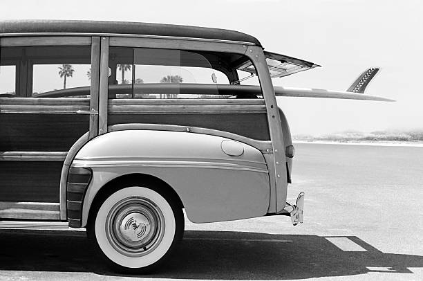 Old Woodie Station Wagon with Surfboard This is a photo that was originally taken with black and white film and later scanned as a digital file. There is space above the woodie that can be extended vertically to add copy if desired.Click on the links below to view lightboxes. domestic car photos stock pictures, royalty-free photos & images