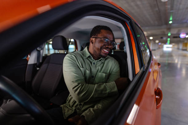 istock A cheerful Black man putting on his seat belt. Driving safe. 1852807178