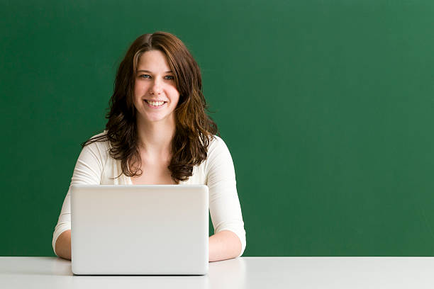 estudiante sonriente con ordenador portátil - 20s attractive female beautiful people blackboard fotografías e imágenes de stock