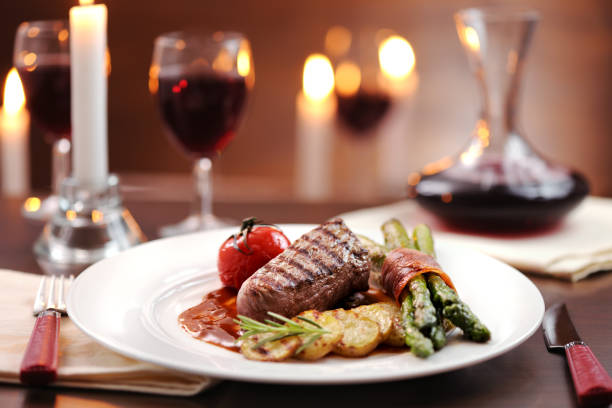 Grilled beef with prosciutto wrapped asparagus,tomato and grilled potato slices on red wine sauce served with red wine