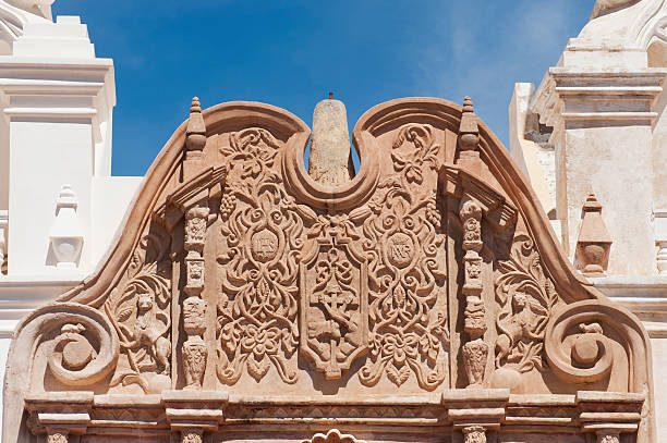 Stone Carved Entrance at San Xavier del Bac Mission "The architectural detail at San Xavier del Bac Mission on the Tohono O'odham Indian Reservation near Tucson, Arizona is stunning.  This ornate carving stands over the entrance to the the cathedral at the mission." tohono o'odham stock pictures, royalty-free photos & images