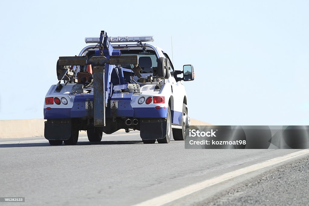 Tow Truck Rear quarter view of a nondescript tow truck travelling on a highway.  Shallow dof with focus on rear of truck. Slight motion blur. Tow Truck Stock Photo