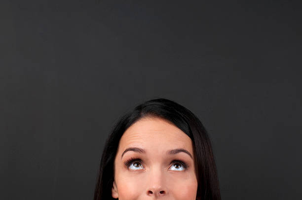istock Woman glancing upwards thinking of different ideas 185282895