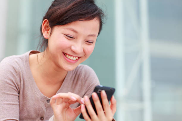 istock pretty young woman reading message on mobile phone 185283170