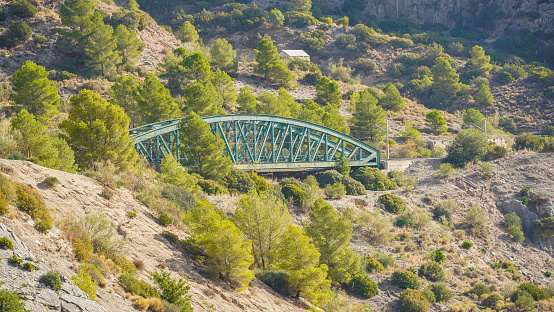 Puente ferroviario con protección anti derrumbes en una ladera de una montaña mediterránea