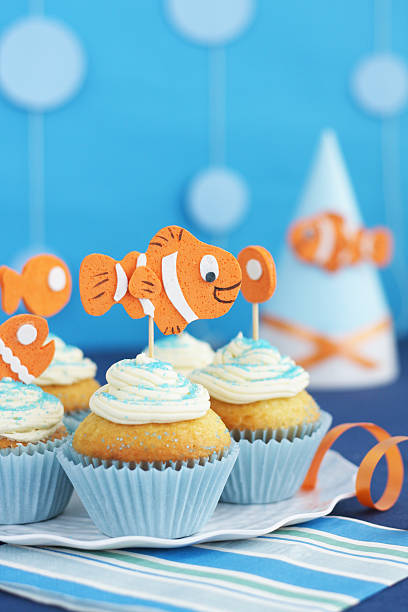 Under the sea party with cupcakes and birthday hat. Defocused bubbles garlands in the background.