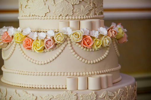 Elegant cake for a wedding celebration decorated with flowers made of caramel.