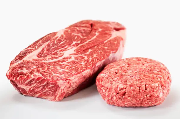 "Whole USDA Prime grade chuck eye roast, and a patty of ground beef made from it.  Shallow DOF."