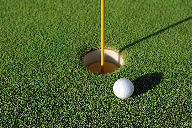 golfball in der nähe von loch-xl - golf golf flag sunset flag stock-fotos und bilder