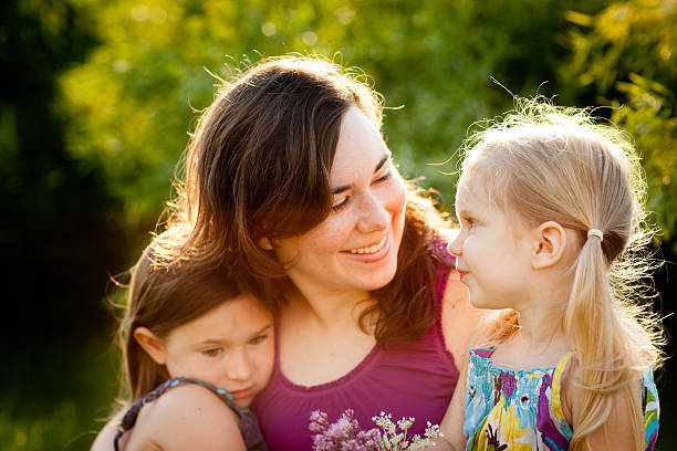 istock Happy Mother and Two Daughters Sitting Together Outside 185284635