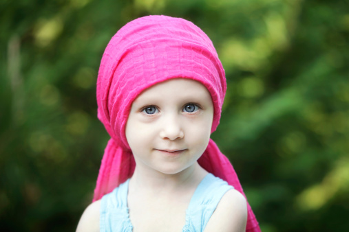 Depiction of child with the effects of chemotherapy. Outdoors