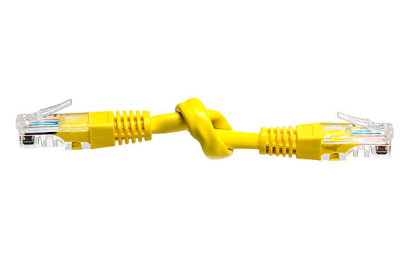 Knot in a patch cable, isolated. Broken network. Knot on a network (cat5) patch cable. Isolated on a white background.Concept idea for a broken network. Disabled data communication. broadband isp stock pictures, royalty-free photos & images