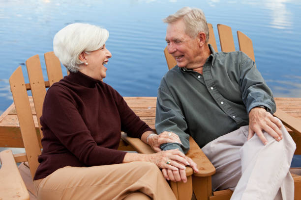 istock Happy senior couple sitting by water 185285710