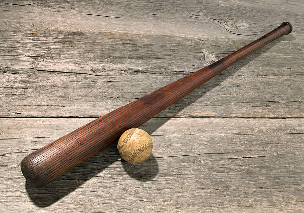 Antique bat and baseball on weathered wood