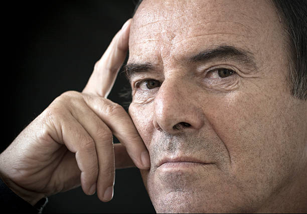 Closeup portrait of a man in his 70s wearing a hat.
