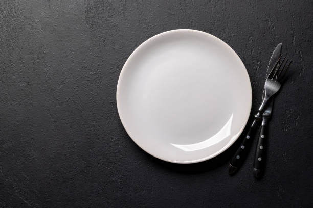 istock Mockup for a delicious meal. Empty plate on a table 1852871668