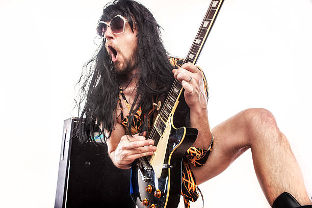 Fun seventies style. A girl posing in a black wig with a toy guitar, portraying a rock singer