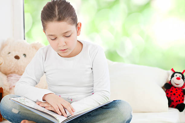 istock Beautiful little girl reading 185287316