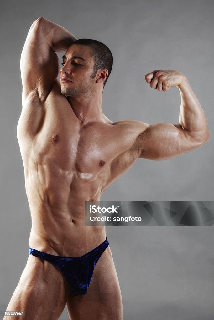 Bodybuilder flexing muscles looking away Bodybuilder flexing muscles looking away. Body Building Stock Photo