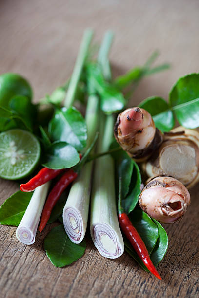 Thai Tom Yam soup herbs and spices. Thai Tom Yam soup herbs and spices, consisting of Lemongrass, Kaffir Lime leaves, Galangal, Lemon and Red Chilli. Very shallow depth of field. kaffir stock pictures, royalty-free photos & images