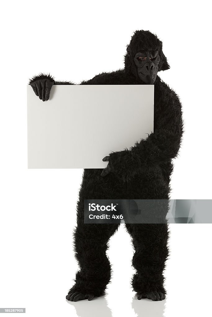 Homme en costume tenant une pancarte Gorille - Photo de Gorille libre de droits