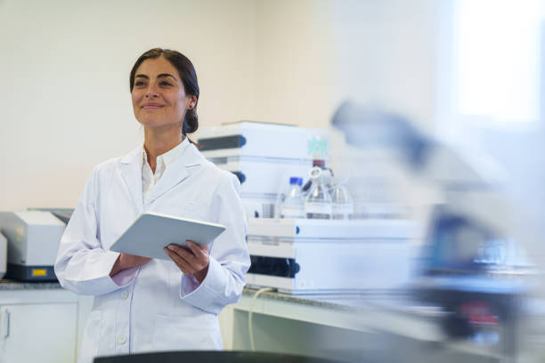 istock Young female lab technician holding digital tablet inside research facility 1852883695
