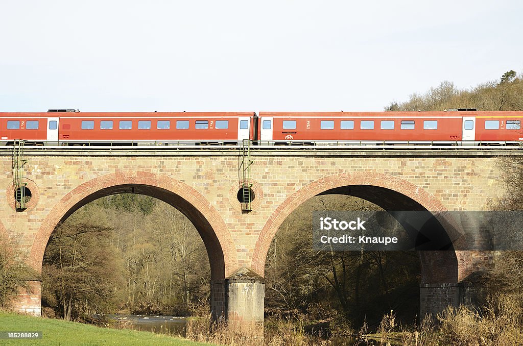 Red train sur Arche de Pont sur la rivière - Photo de Arc - Élément architectural libre de droits