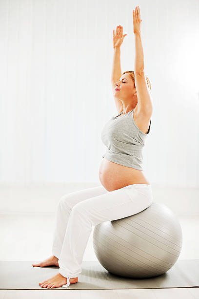 красивая беременная женщина, делать упражнения. - human pregnancy prenatal care relaxation exercise ball стоковые фото и изображения